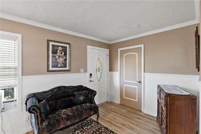 living area with light hardwood / wood-style flooring, ornamental molding, and plenty of natural light