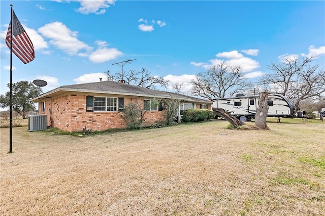 exterior space with central AC unit and a front lawn