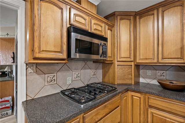 kitchen with tasteful backsplash and appliances with stainless steel finishes