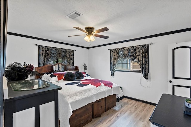 bedroom with crown molding, light wood-type flooring, a textured ceiling, and ceiling fan