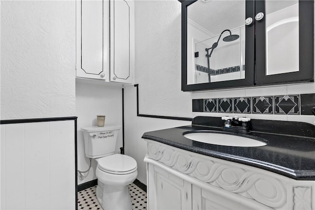 bathroom with toilet, a shower, crown molding, vanity, and decorative backsplash