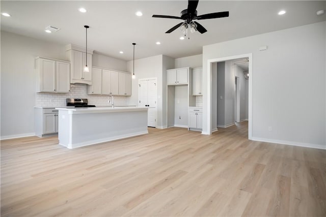 3711 Archer Falls Ct, College Station, TX 77845 - kitchen with stainless steel range, decorative backsplash, light wood-style flooring, recessed lighting, and ceiling fan