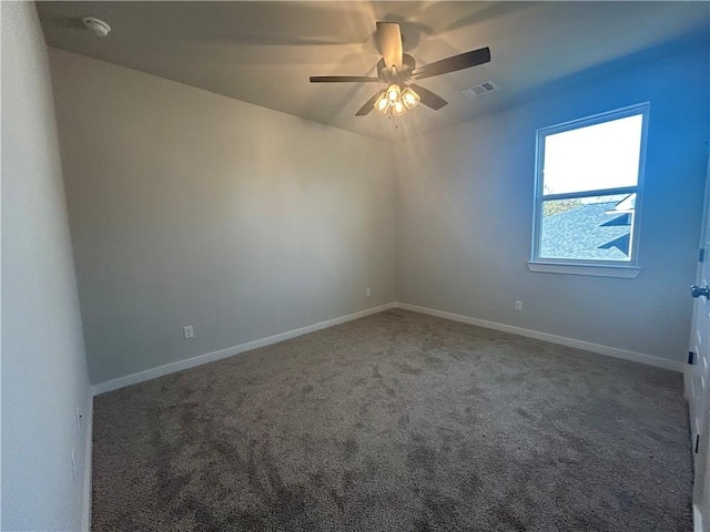 carpeted empty room featuring baseboards, visible vents, and ceiling fan