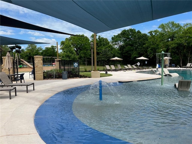 community pool with playground community, a patio, and fence