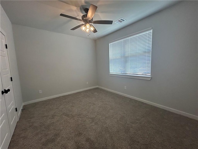 unfurnished room featuring carpet floors, baseboards, visible vents, and a ceiling fan