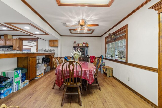 dining room with ceiling fan, light wood-type flooring, and ornamental molding