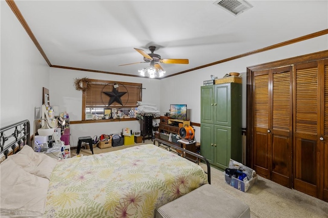 carpeted bedroom with a closet, visible vents, ceiling fan, and ornamental molding