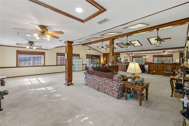 carpeted living room with decorative columns, vaulted ceiling with beams, and ornamental molding