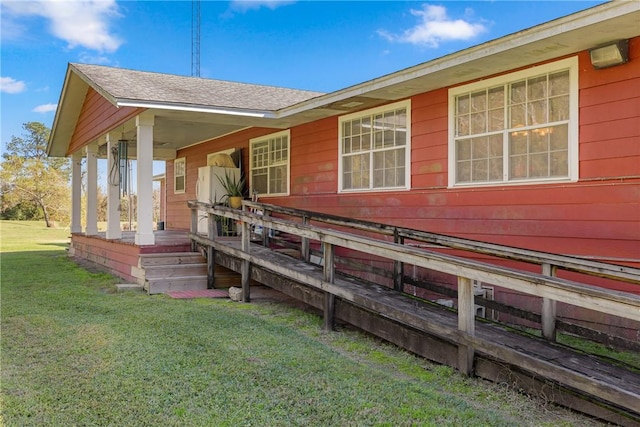 rear view of house with a lawn and covered porch