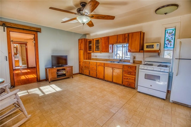 6196 Fm 975, Caldwell, TX 77836 - kitchen with sink, white appliances, a barn door, and ceiling fan