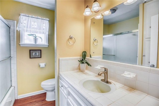 6196 Fm 975, Caldwell, TX 77836 - full bathroom featuring combined bath / shower with glass door, hardwood / wood-style floors, tasteful backsplash, vanity, and toilet