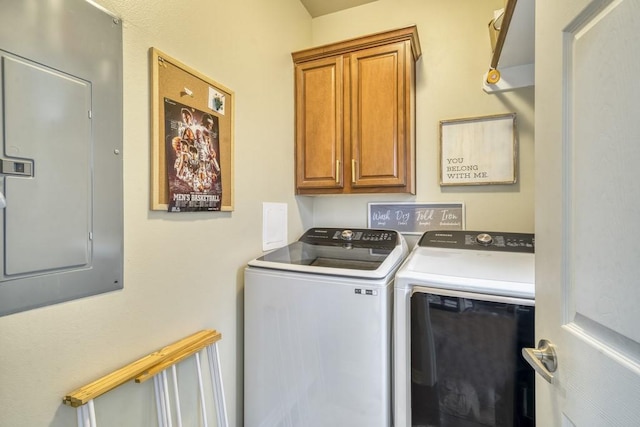 washroom with separate washer and dryer, cabinet space, and electric panel