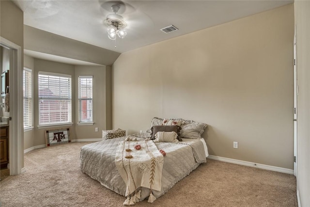 bedroom with light carpet, vaulted ceiling, visible vents, and baseboards