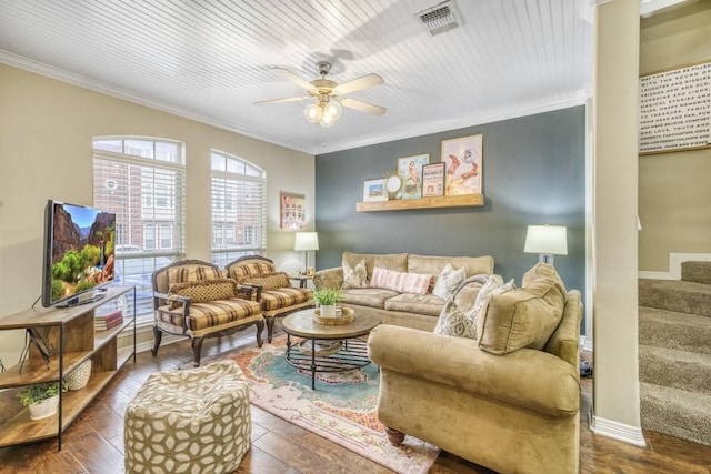 living room featuring a ceiling fan, baseboards, stairs, visible vents, and crown molding