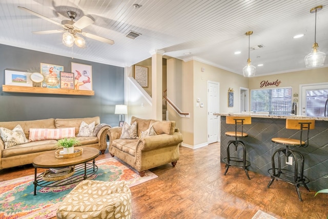 living room with baseboards, stairs, visible vents, and crown molding