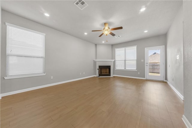 unfurnished living room with visible vents, wood finished floors, recessed lighting, a fireplace, and ceiling fan