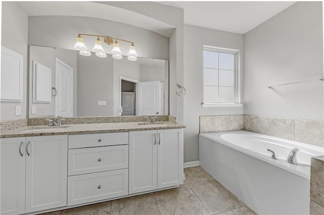 bathroom featuring a sink, a bath, double vanity, and tile patterned flooring