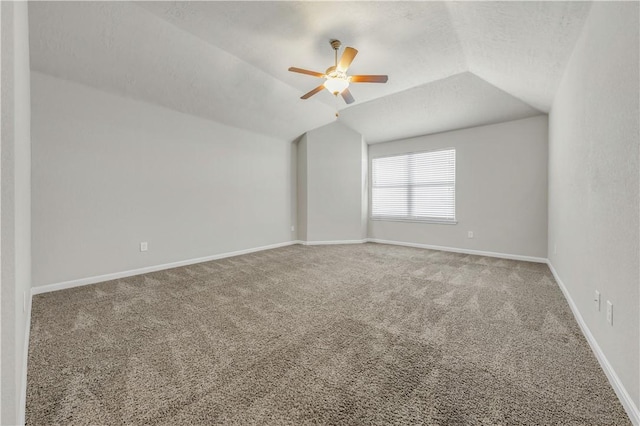 empty room with baseboards, carpet floors, lofted ceiling, and a ceiling fan