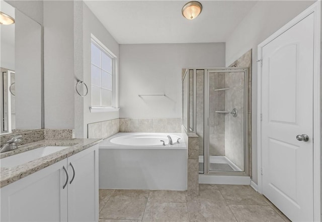 bathroom featuring vanity, a shower stall, a garden tub, and tile patterned floors