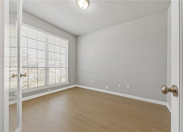 unfurnished room featuring baseboards and wood finished floors