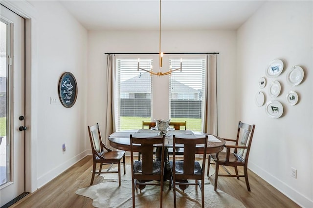 4302 Fox River Ln, Bryan, TX 77802 - dining space featuring wood finished floors, an inviting chandelier, baseboards, and a healthy amount of sunlight