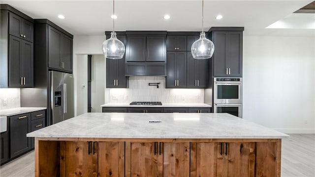10017 Panther Creek Dr, Iola, TX 77861 - kitchen with appliances with stainless steel finishes, light wood finished floors, backsplash, a spacious island, and recessed lighting