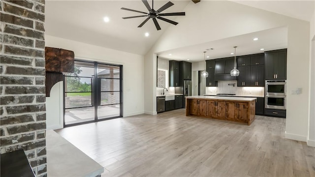 10017 Panther Creek Dr, Iola, TX 77861 - kitchen with stainless steel appliances, a ceiling fan, light countertops, light wood-type flooring, and tasteful backsplash