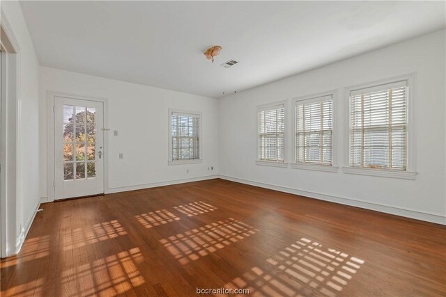 spare room with a healthy amount of sunlight and wood-type flooring