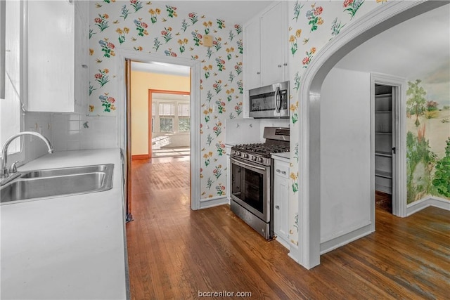 kitchen with dark hardwood / wood-style flooring, sink, white cabinets, and appliances with stainless steel finishes