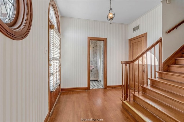 foyer entrance featuring hardwood / wood-style floors and ornamental molding