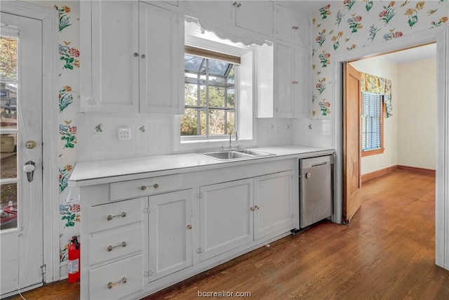 kitchen featuring sink, tasteful backsplash, light hardwood / wood-style flooring, stainless steel dishwasher, and white cabinets