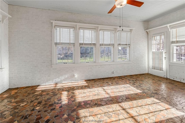 empty room with ceiling fan and a healthy amount of sunlight