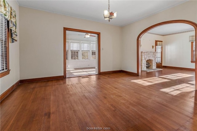 unfurnished living room with crown molding, wood-type flooring, and ceiling fan with notable chandelier