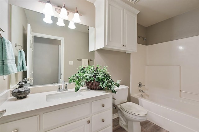 bathroom with shower / bathing tub combination, vanity, toilet, and wood finished floors