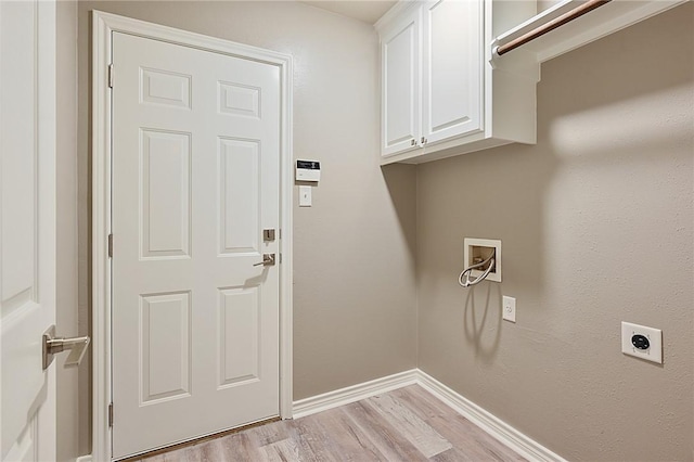 washroom with hookup for a washing machine, cabinet space, light wood-style floors, electric dryer hookup, and baseboards