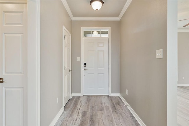 entrance foyer featuring light wood-style flooring, baseboards, and crown molding