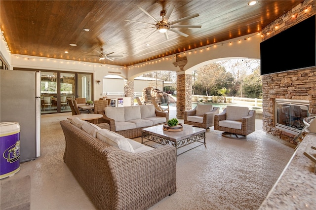 view of patio featuring an outdoor living space with a fireplace, outdoor dining area, french doors, and ceiling fan