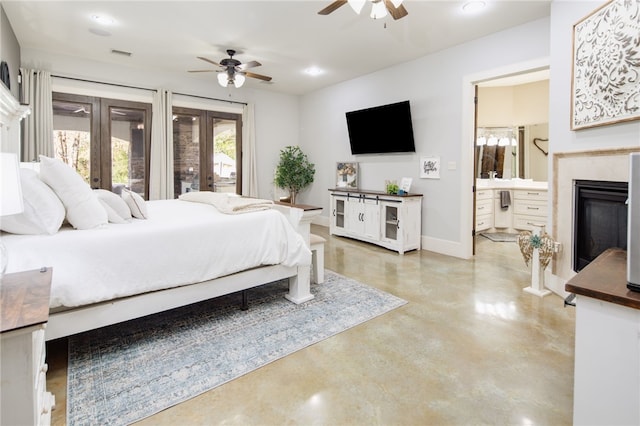 bedroom featuring visible vents, ensuite bath, finished concrete floors, french doors, and a glass covered fireplace