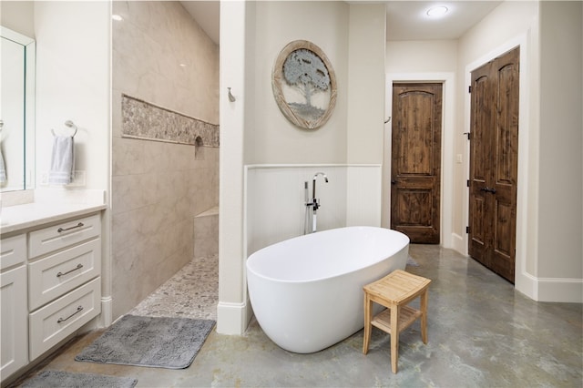 full bath featuring vanity, finished concrete flooring, a walk in shower, and a freestanding bath