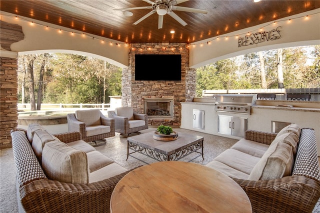 view of patio with exterior kitchen, an outdoor living space with a fireplace, fence, and grilling area