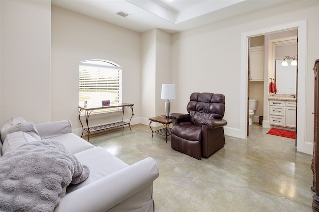 living room with visible vents, concrete floors, and baseboards