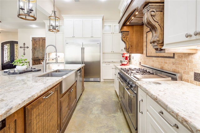 kitchen with brown cabinetry, premium appliances, backsplash, and a sink