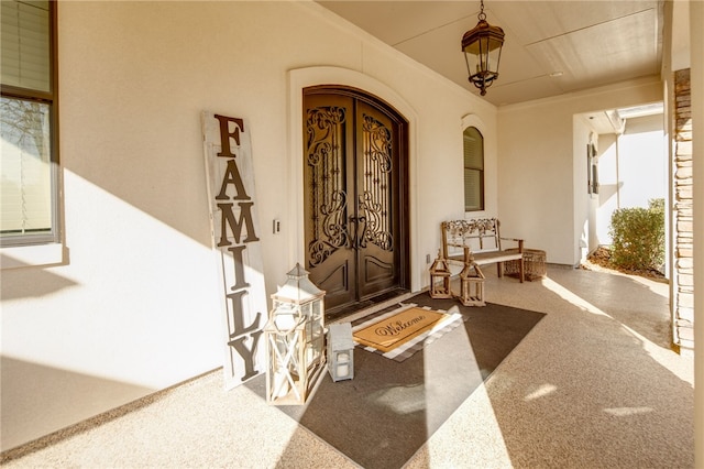 view of exterior entry featuring stucco siding and covered porch