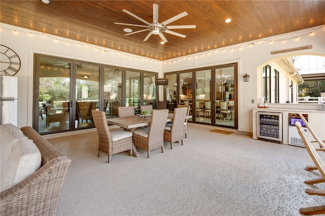 carpeted dining room featuring plenty of natural light, wood ceiling, and beverage cooler