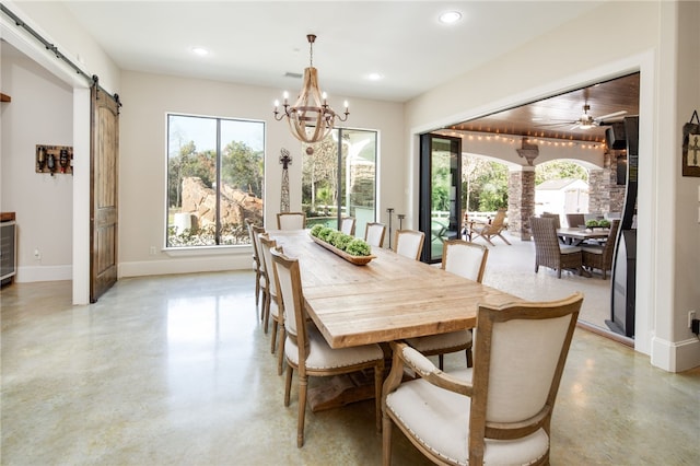 dining room featuring plenty of natural light, baseboards, concrete flooring, and a barn door