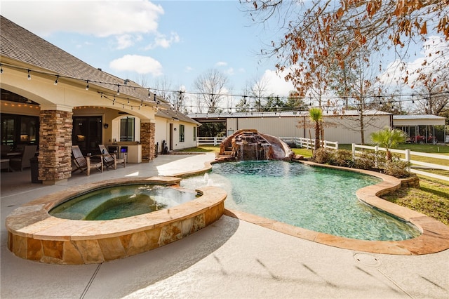 view of swimming pool featuring a patio area, fence, and a pool with connected hot tub