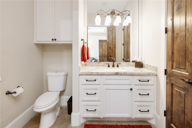 half bath featuring vanity, toilet, and baseboards