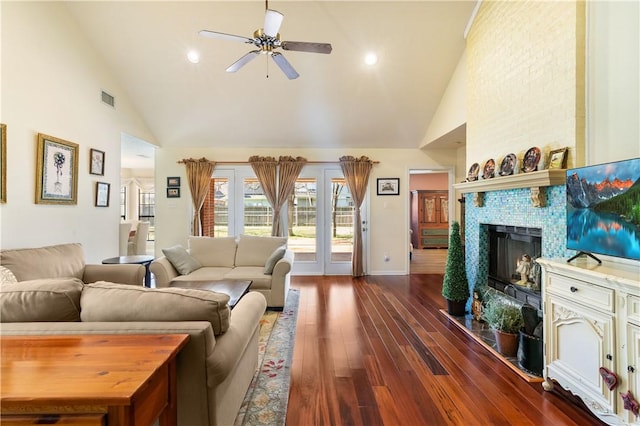 living room featuring a large fireplace, high vaulted ceiling, dark hardwood / wood-style floors, and ceiling fan