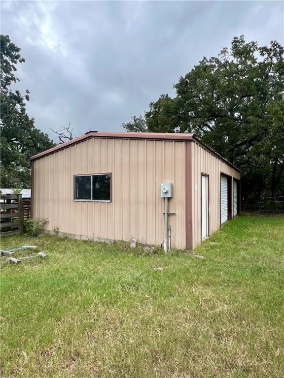 view of outdoor structure with a yard and a garage