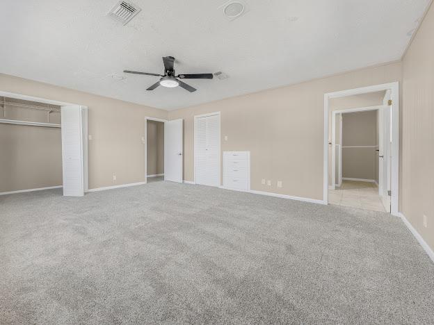 unfurnished bedroom with ceiling fan and light colored carpet